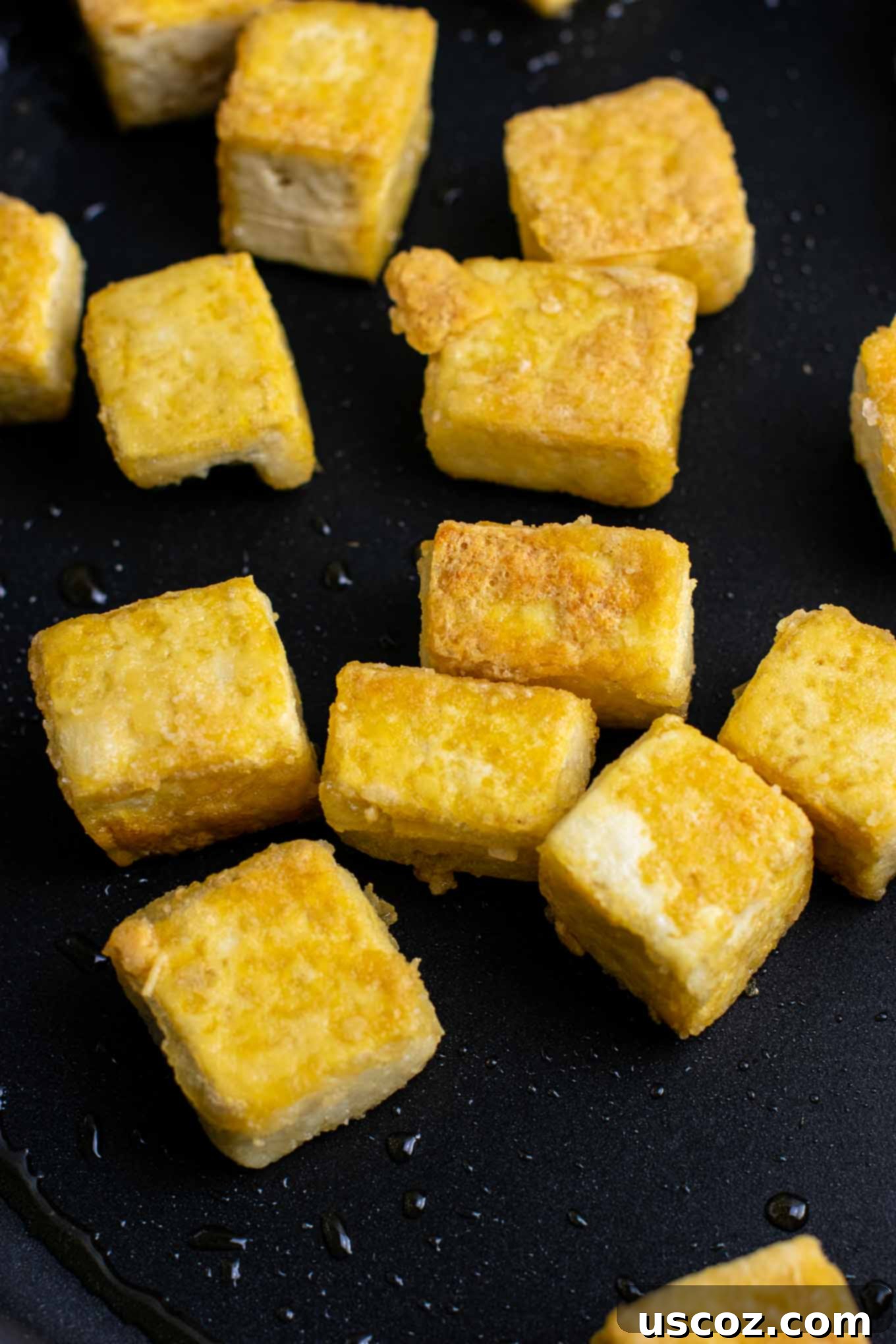 Vibrant Tofu Noodle Stir-Fry 5 Close-up of pan-fried crispy tofu with golden-brown edges in a skillet.