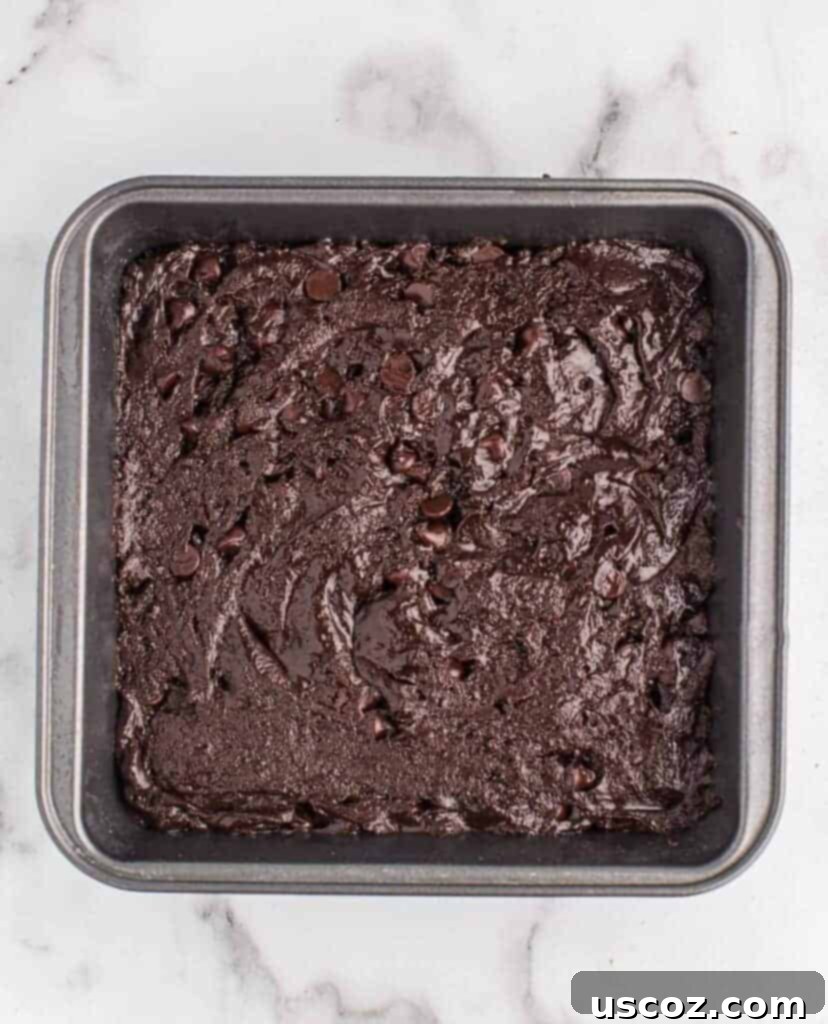 Easy Cake Mix Brownies 9 Brownie batter evenly spread in an 8x8 inch baking dish, ready for the oven.