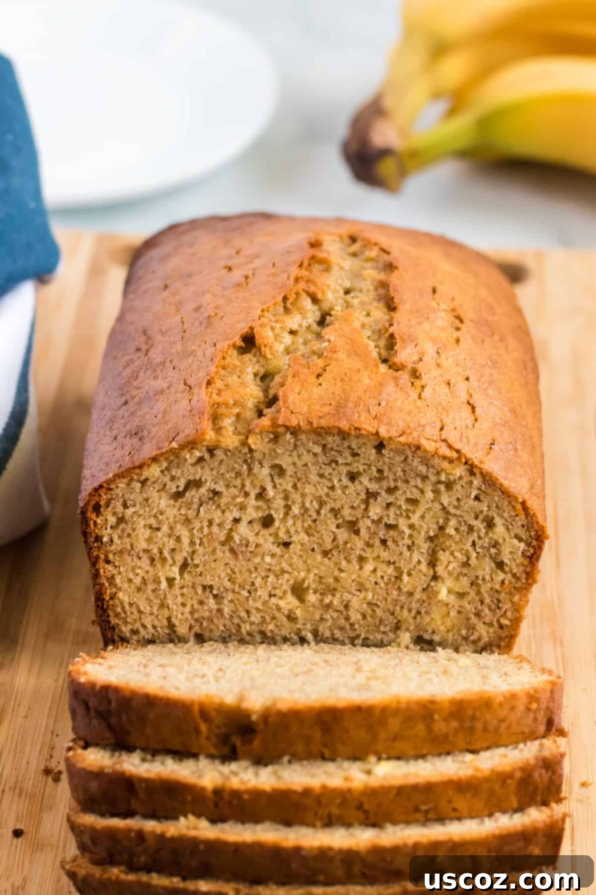 Effortless Cake Mix Banana Bread 2 Sliced cake mix banana bread loaf with a whole banana in the background, ready to be enjoyed.