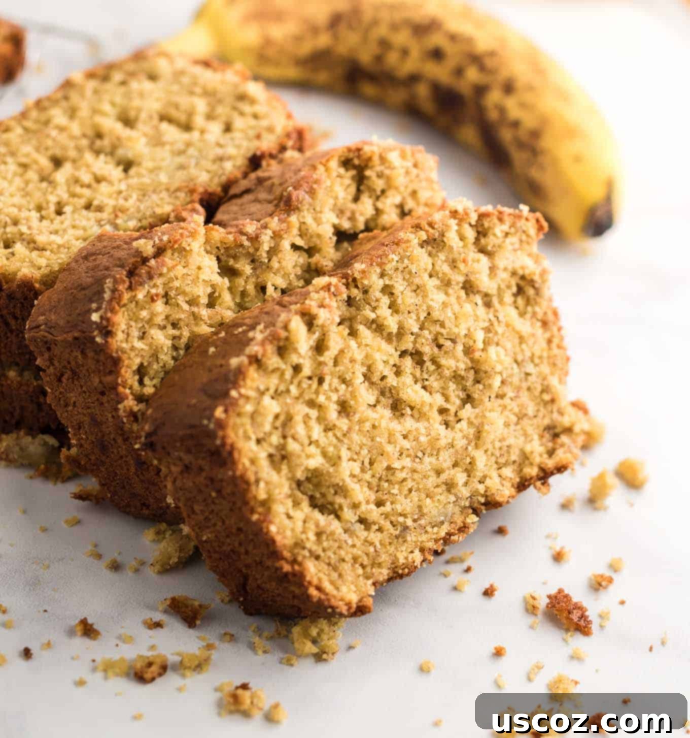 Effortless Cake Mix Banana Bread 3 A beautifully sliced loaf of banana bread on a cutting board, with a fresh banana beside it.