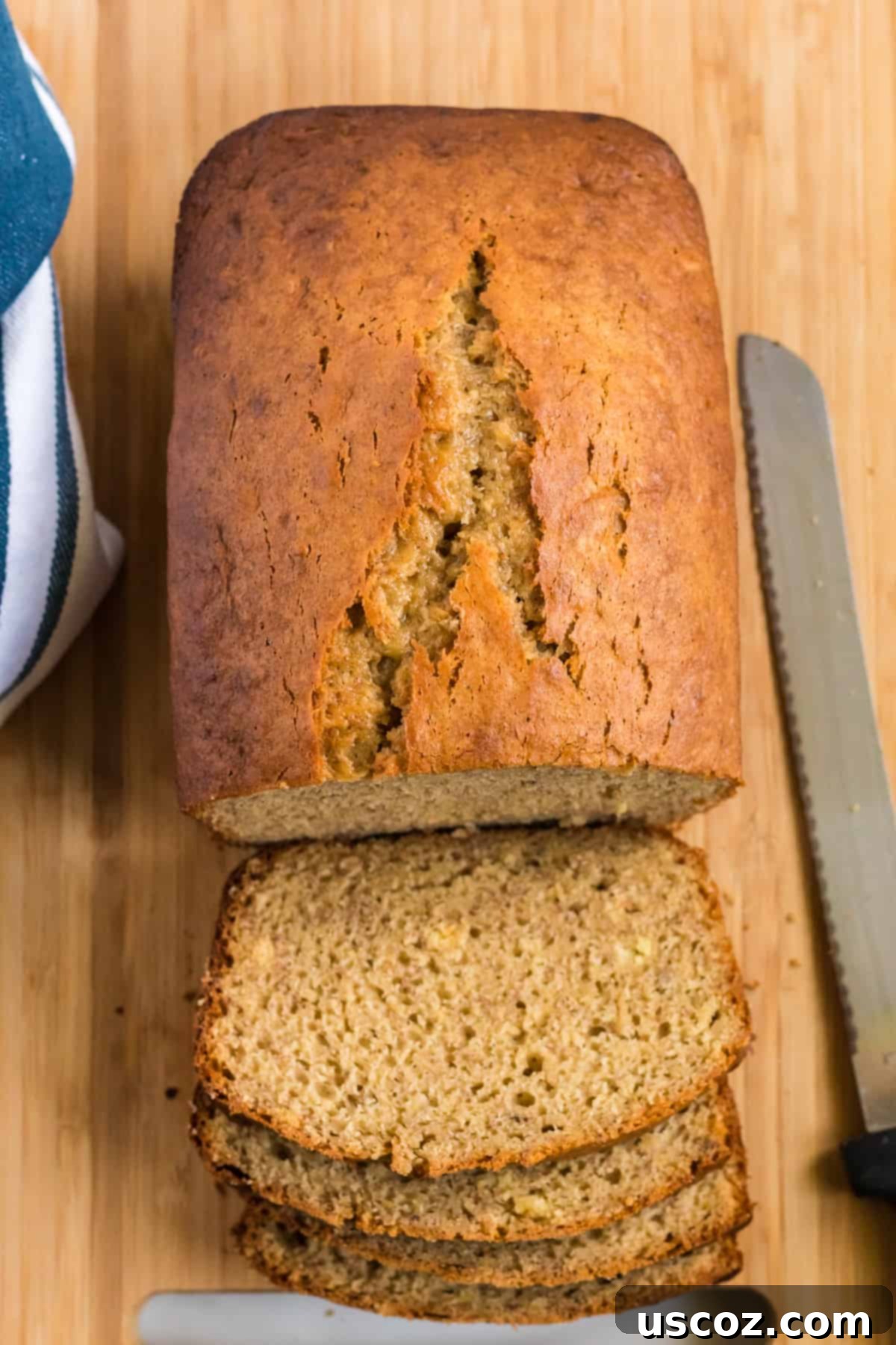 Effortless Cake Mix Banana Bread 6 A freshly baked cake mix banana bread loaf being expertly cut into thick slices.