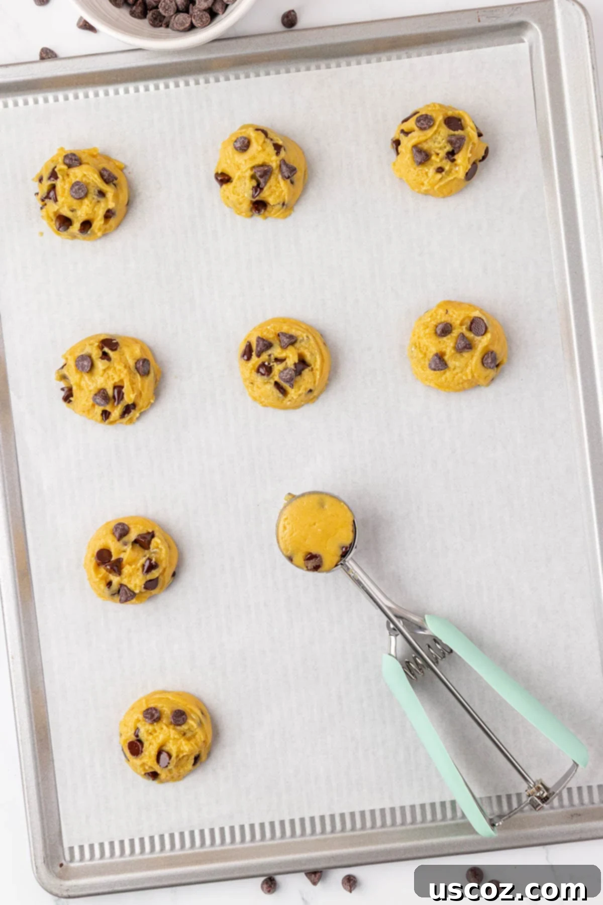 Shortcut Chocolate Chip Cookies 9 Scooped cake mix chocolate chip cookie dough balls placed on a baking sheet, ready for the oven.