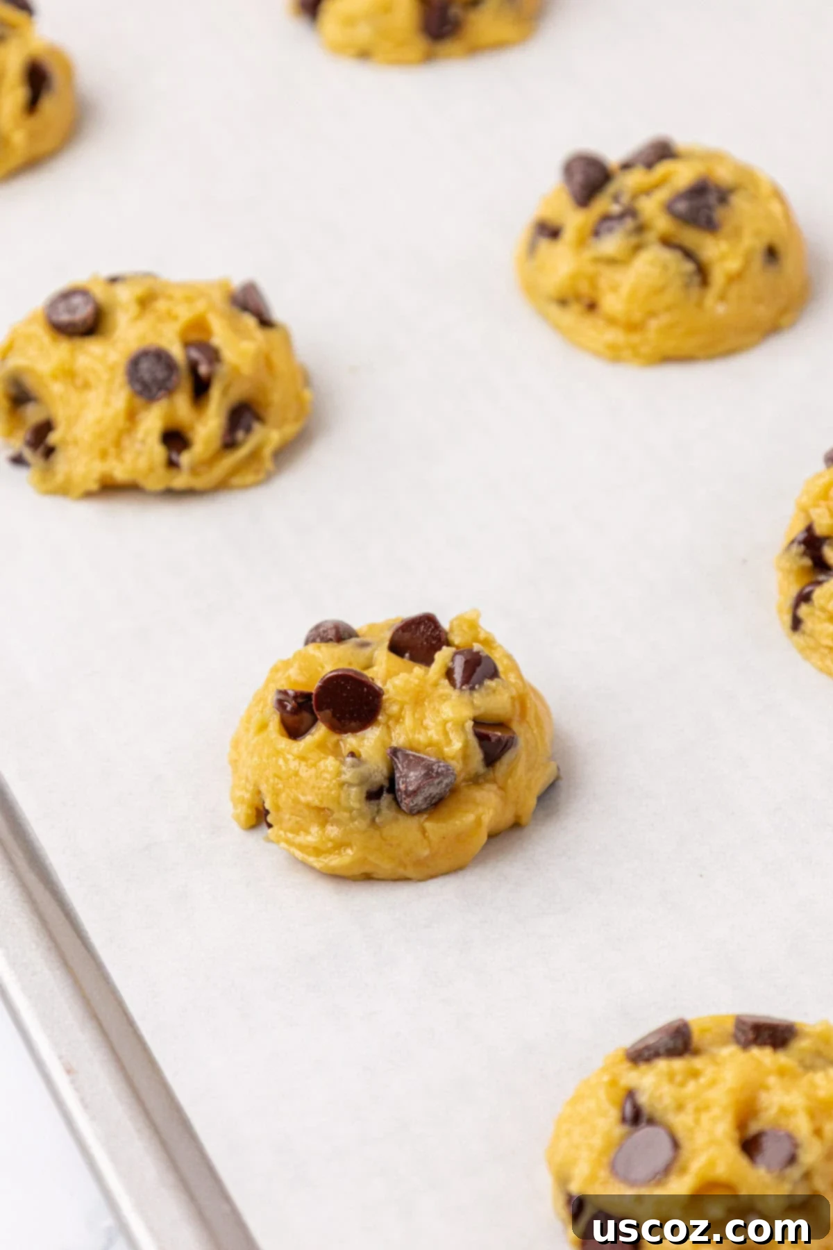 Shortcut Chocolate Chip Cookies 10 Cookie batter portioned on a baking sheet with extra chocolate chips pressed on top.