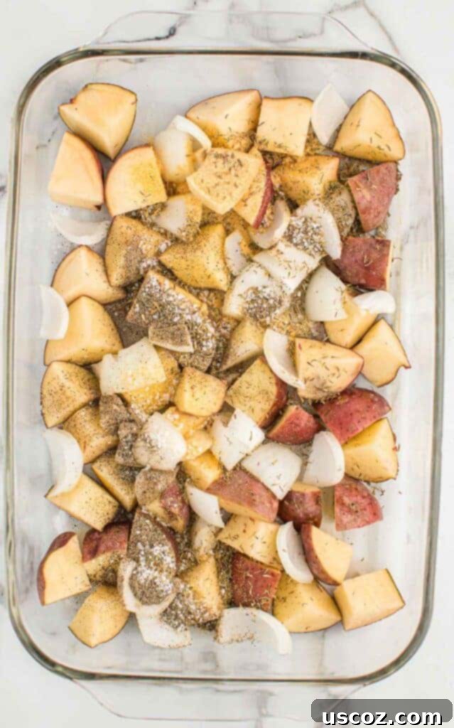 Caramelized Onion and Potato Medley 8 Red potatoes, onions, olive oil, and spices mixed in a glass baking dish, ready for roasting.