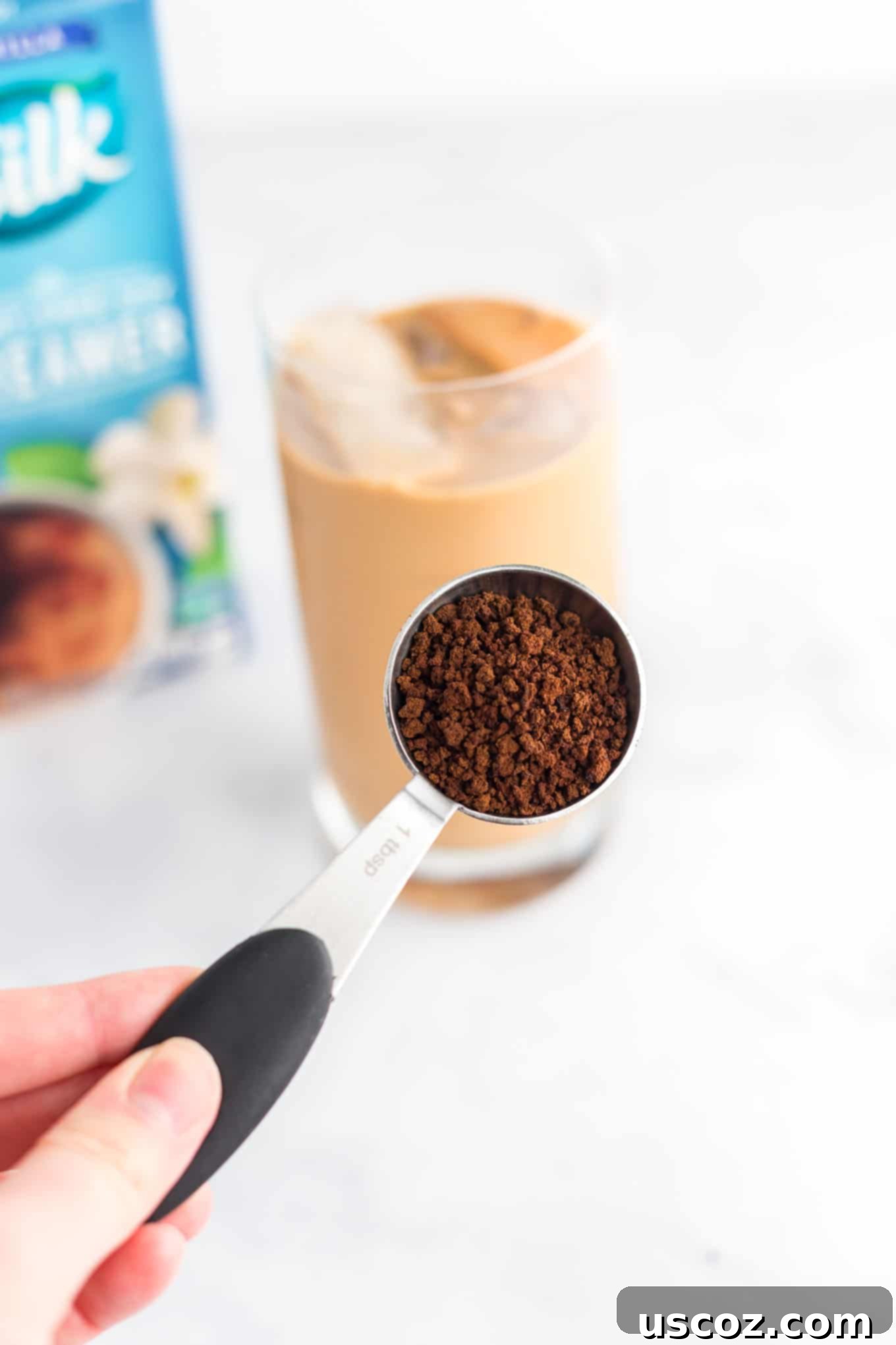 Effortless Instant Iced Coffee 4 A close-up shot of a tablespoon full of instant coffee grounds, highlighting the simplicity of the main ingredient.