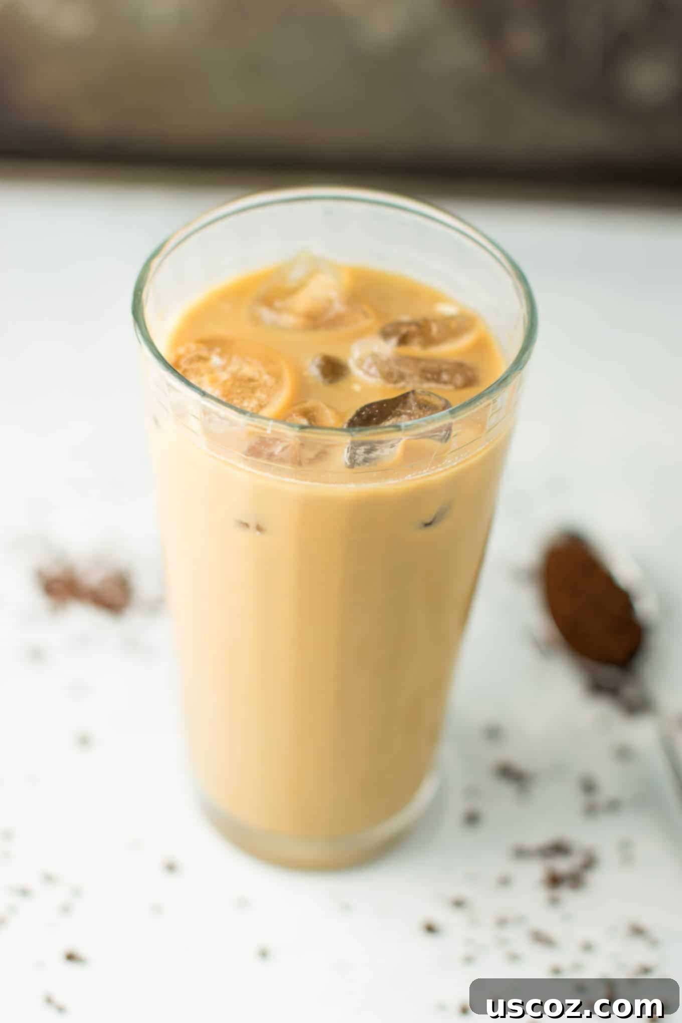 Effortless Instant Iced Coffee 5 A hand stirring a glass of instant iced coffee, showing the creamy texture and inviting appearance.