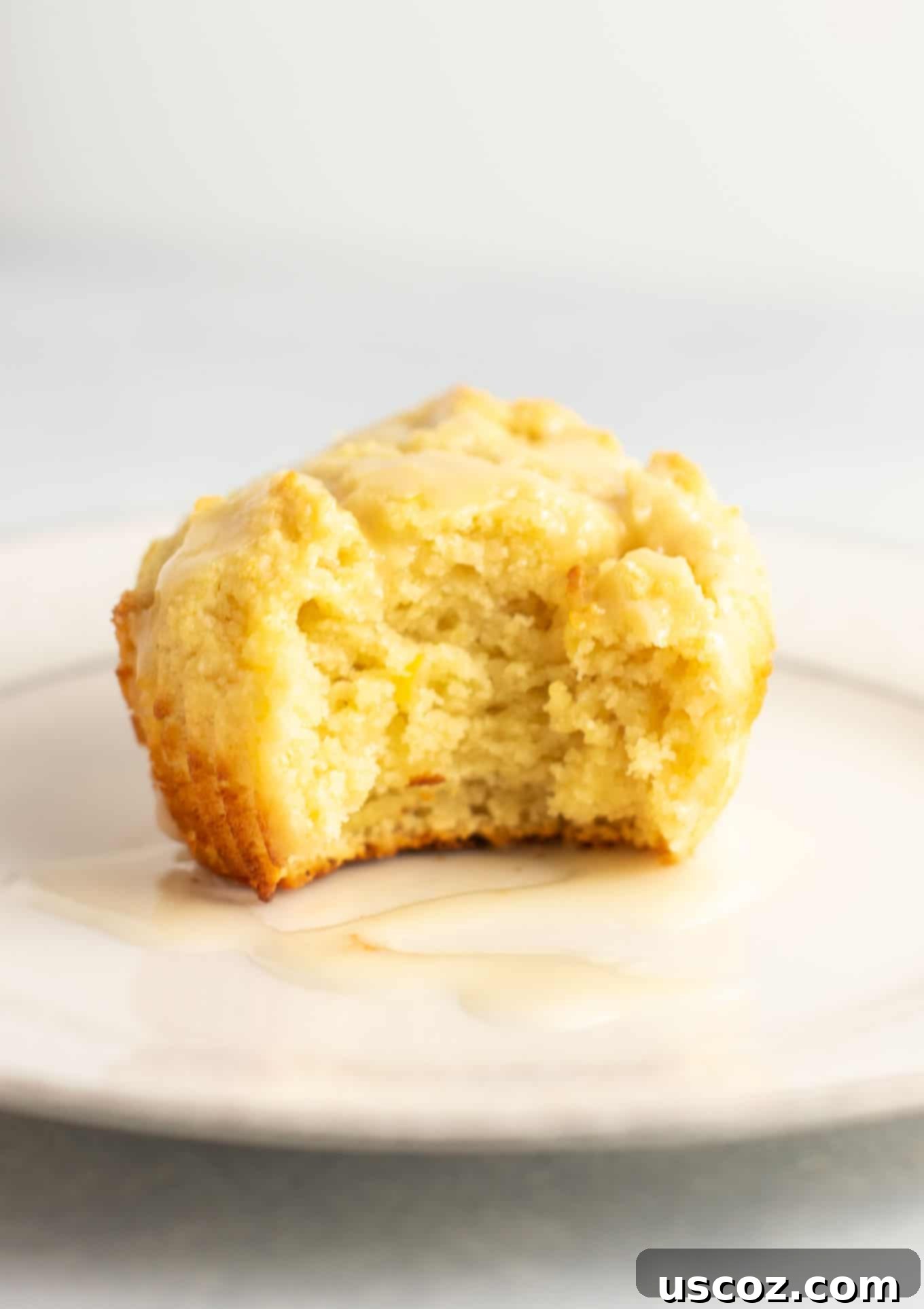 Zesty Gluten Free Lemon Muffins 4 Stack of gluten-free lemon muffins with a generous sweet lemon glaze, highlighting their moist interior and zesty appeal. #glutenfree #lemonmuffins #breakfast