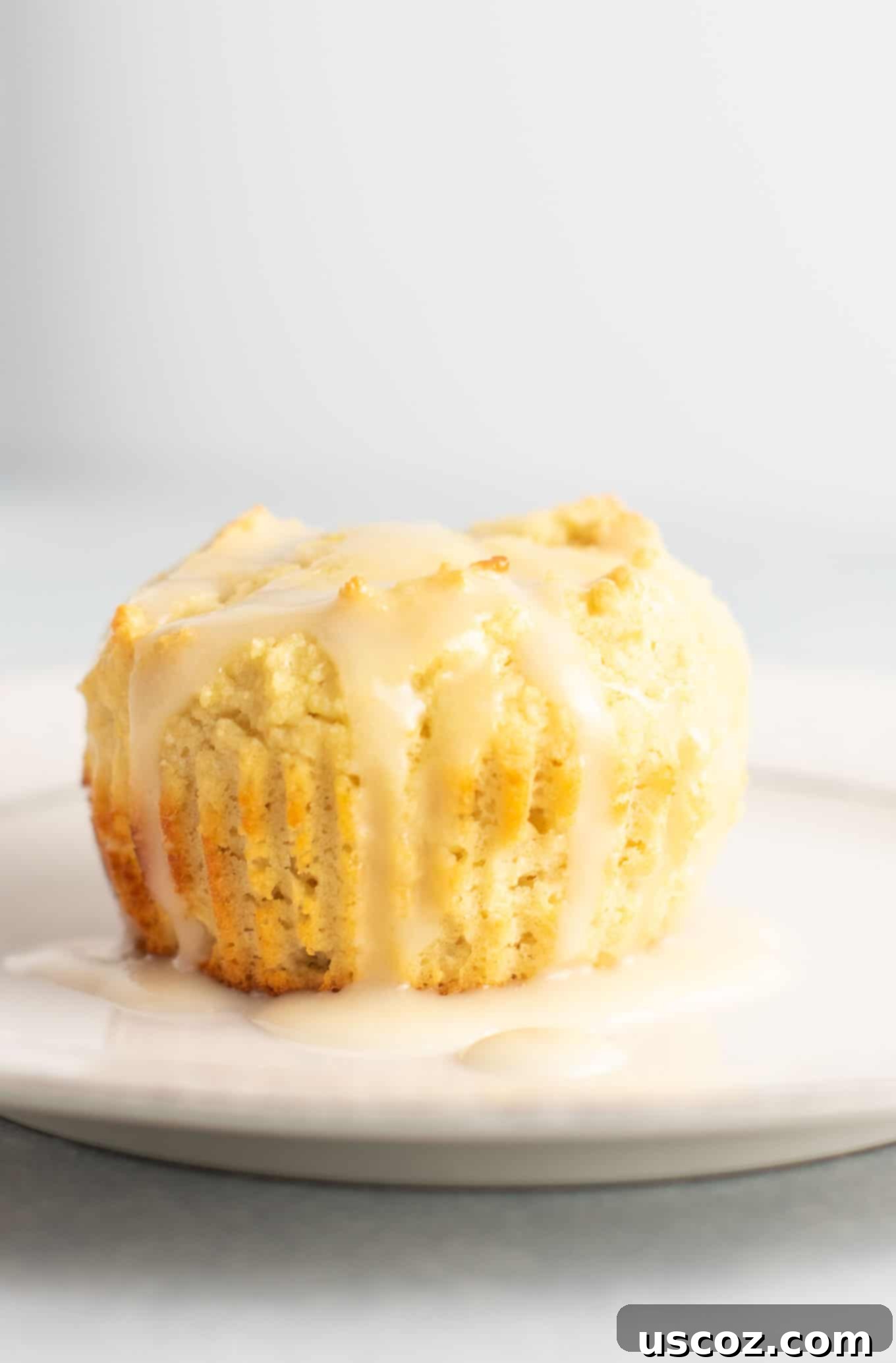 Zesty Gluten Free Lemon Muffins 8 Close-up of the light, moist texture inside a gluten-free lemon muffin, covered in sweet lemon glaze. #glutenfree #lemonmuffins #breakfast