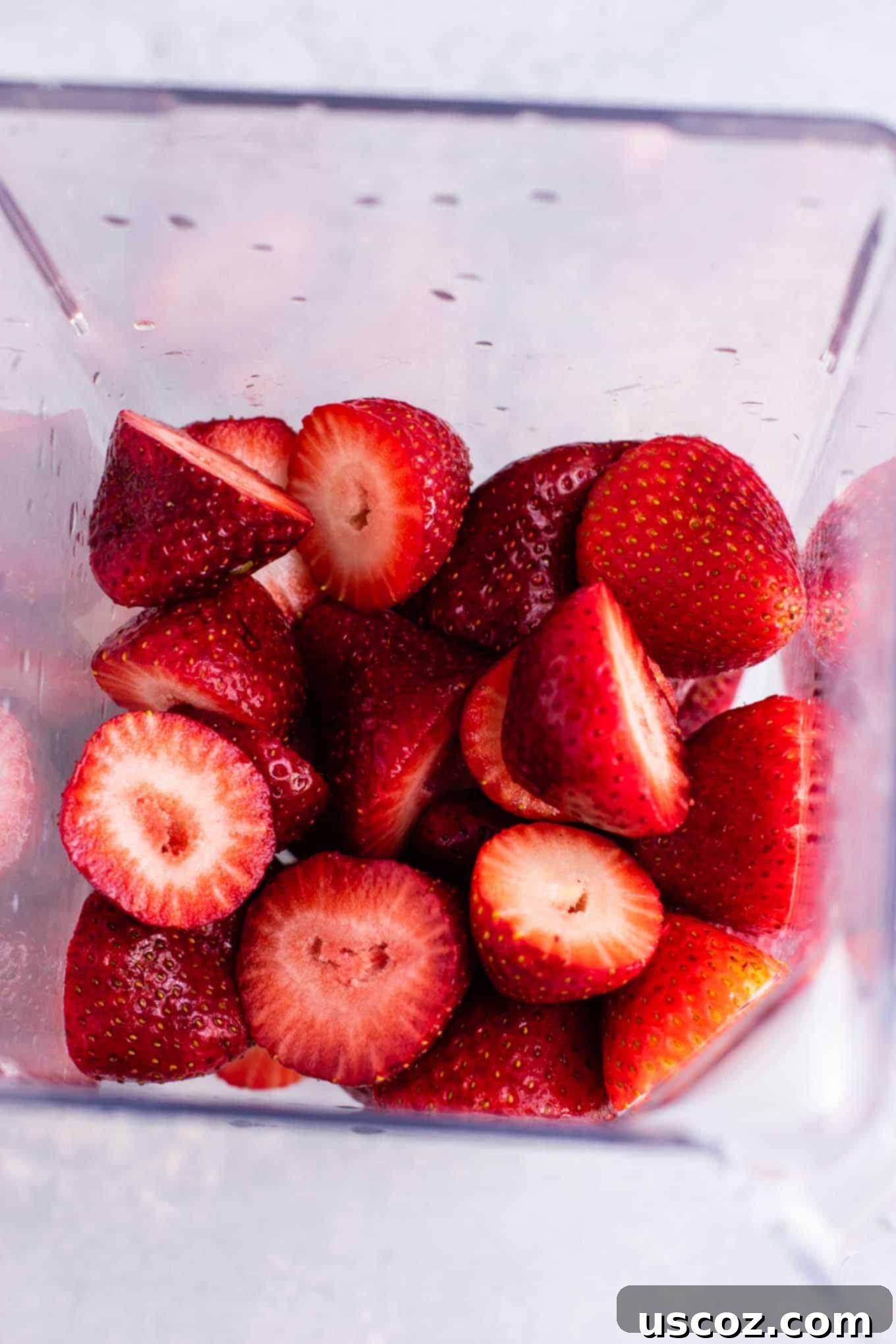 Sip into Summer: 11 Refreshing Smoothie Recipes 4 Close-up of vibrant red strawberries being added to a blender, ready to be transformed into a delicious smoothie.
