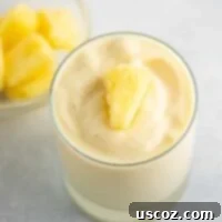 Sip into Summer: 11 Refreshing Smoothie Recipes 8 A frosty pineapple smoothie, thick and creamy, topped with frozen pineapple chunks.