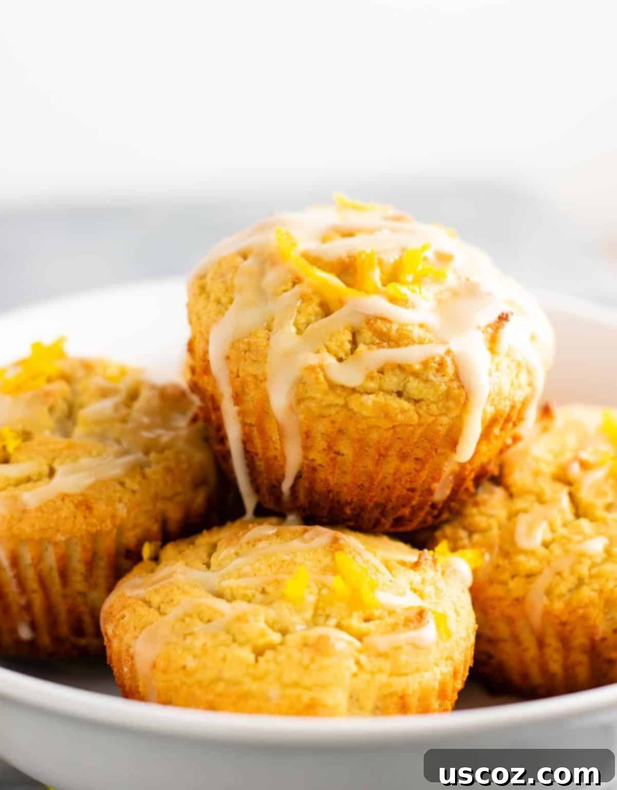 Zesty Gluten Free Orange Muffins 2 Gluten-free orange muffins recipe with sweet orange glaze, piled high on a white plate