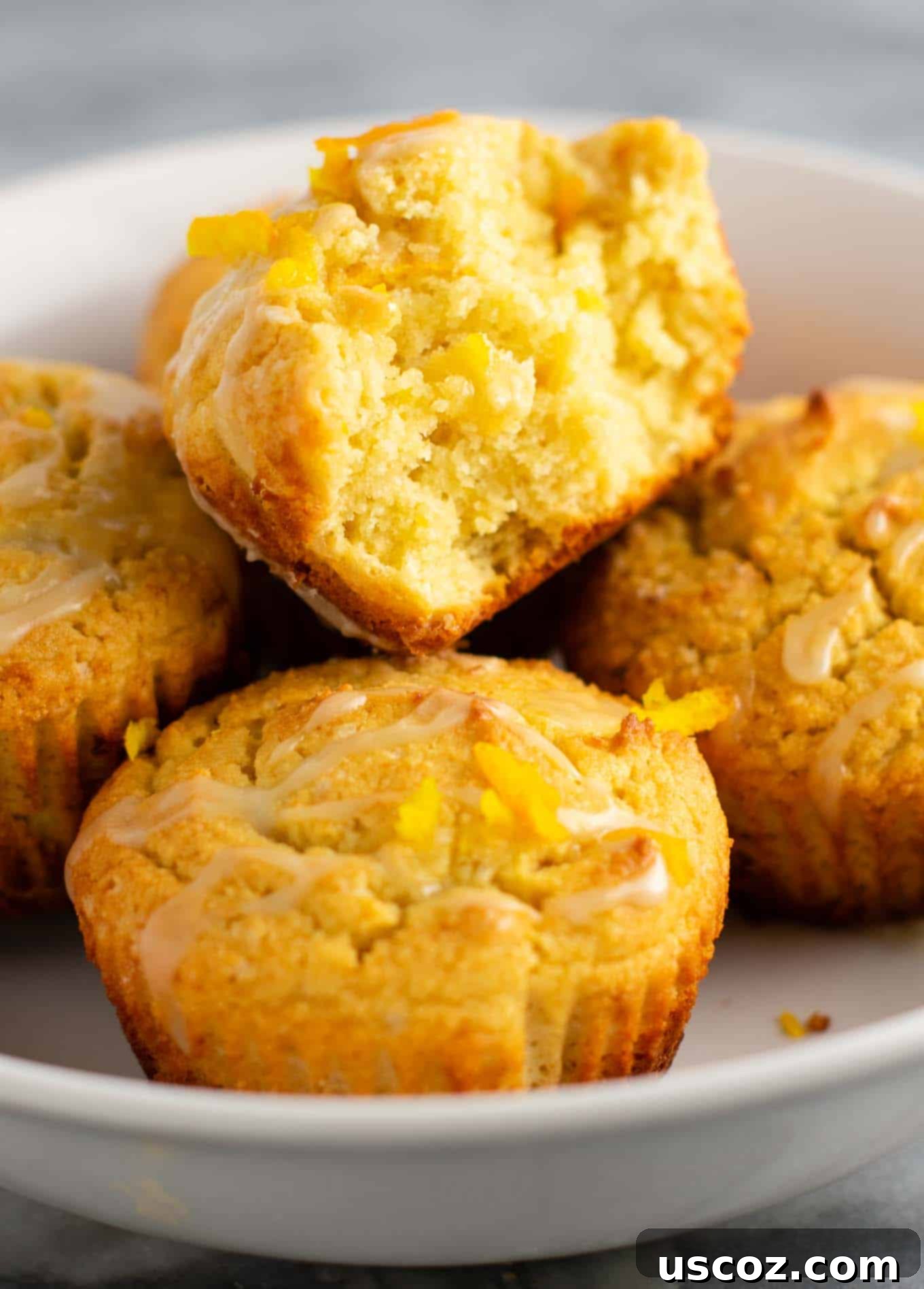 Zesty Gluten Free Orange Muffins 4 Gluten-free orange muffins arranged on a cooling rack, showing the sweet glaze