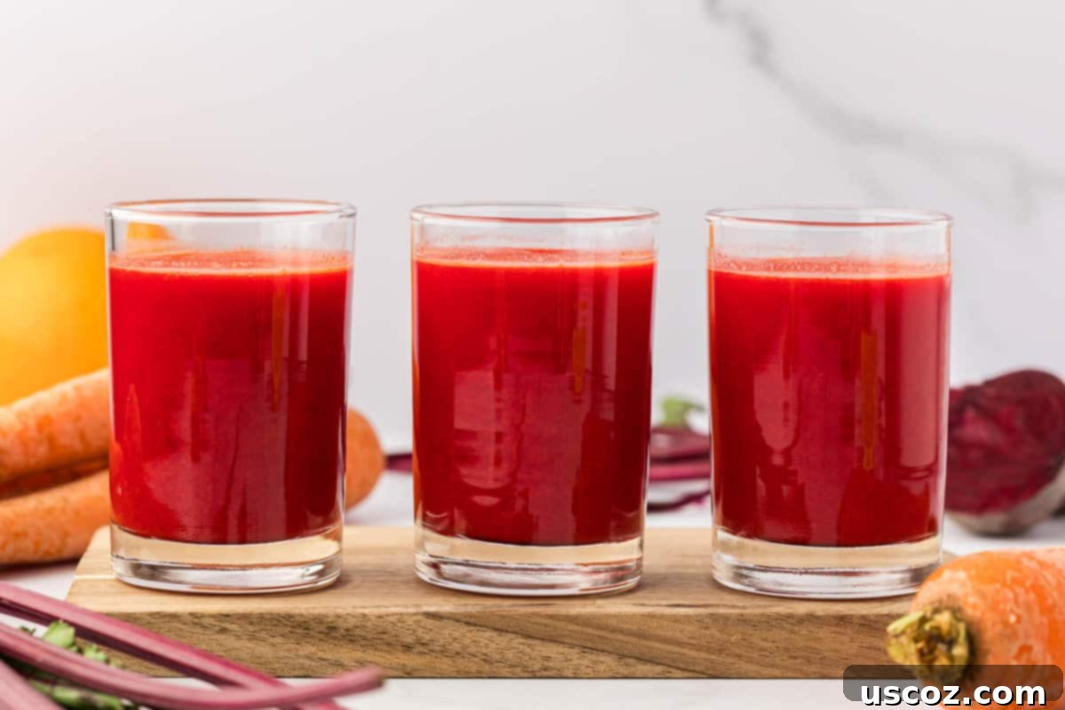 Ruby Root Refresher 12 Two glasses filled with vibrant beet and carrot juice, garnished with mint