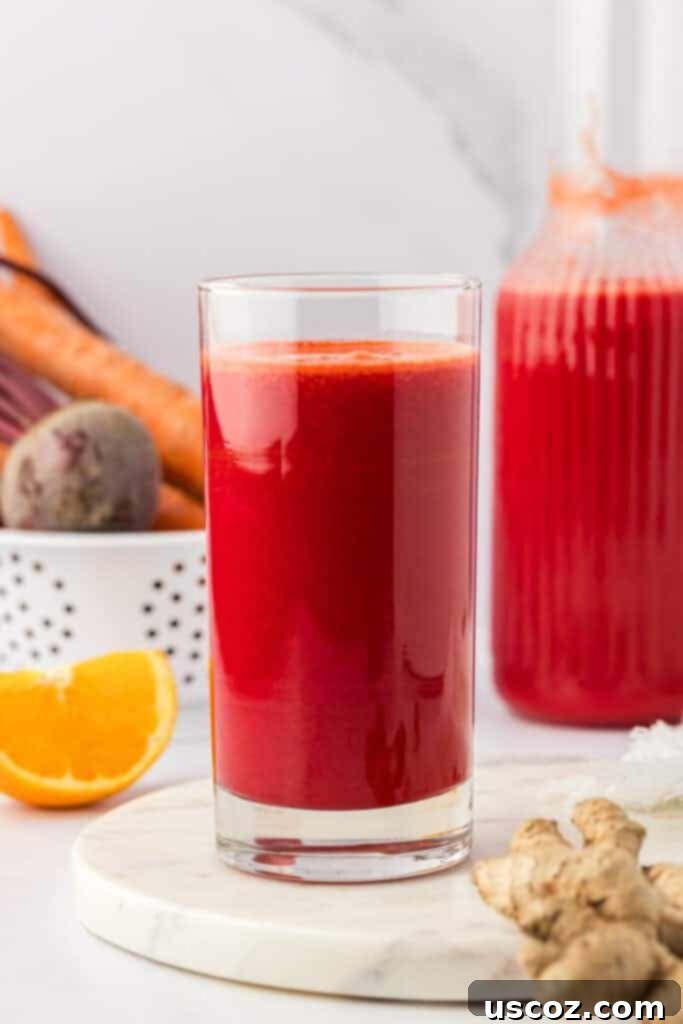 Ruby Root Refresher 8 A close-up of beet and carrot juice in a clear glass with ice