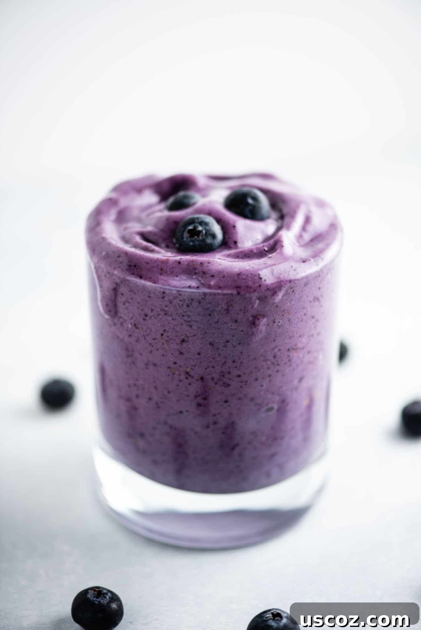 Blueberry Banana Bliss Smoothie 5 A tall glass of blueberry smoothie, showcasing its beautiful purple hue and creamy texture.