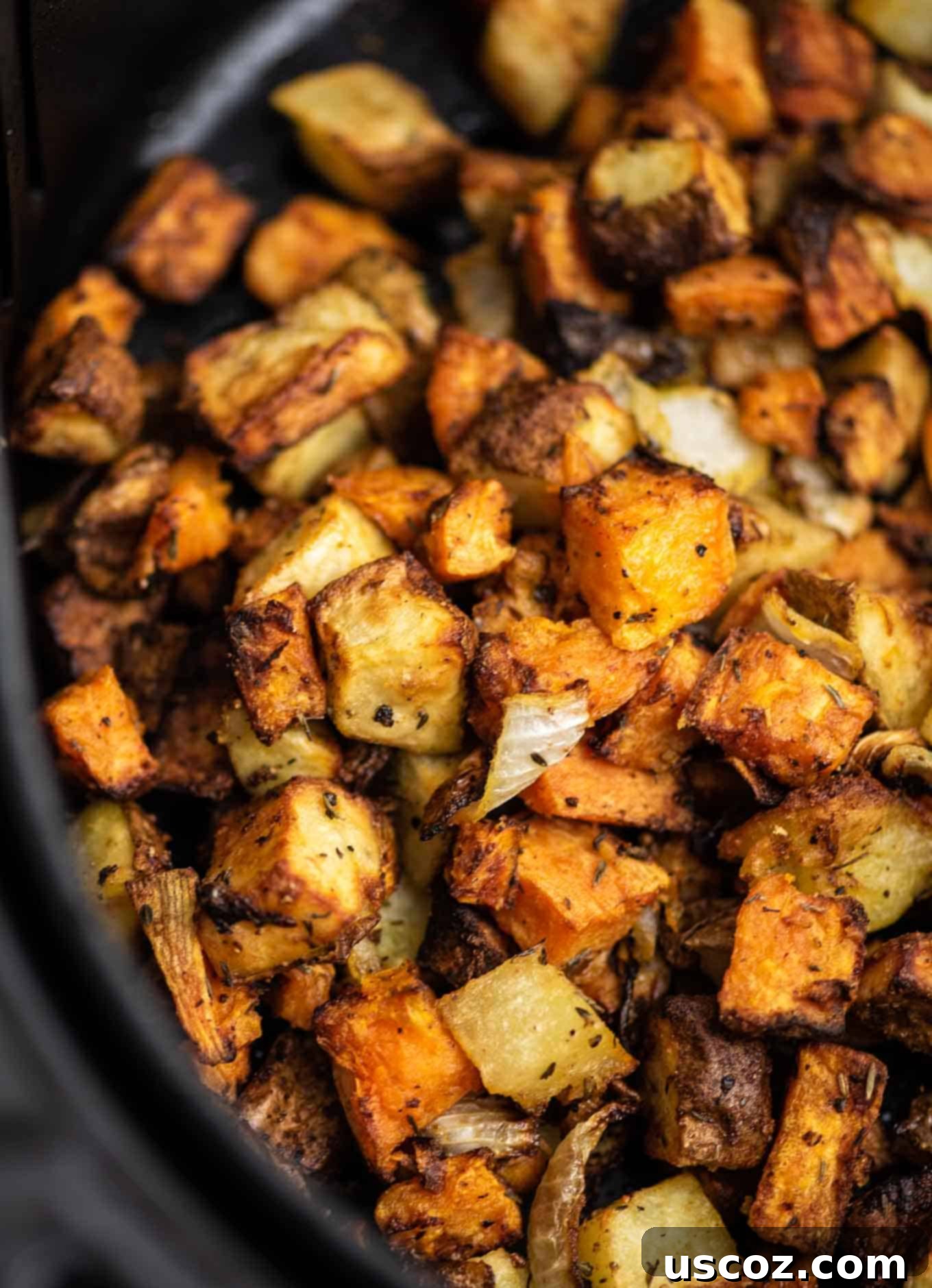Crispy Air Fryer Breakfast Potatoes 5 Air fryer basket filled with seasoned breakfast potatoes and onions from an overhead view