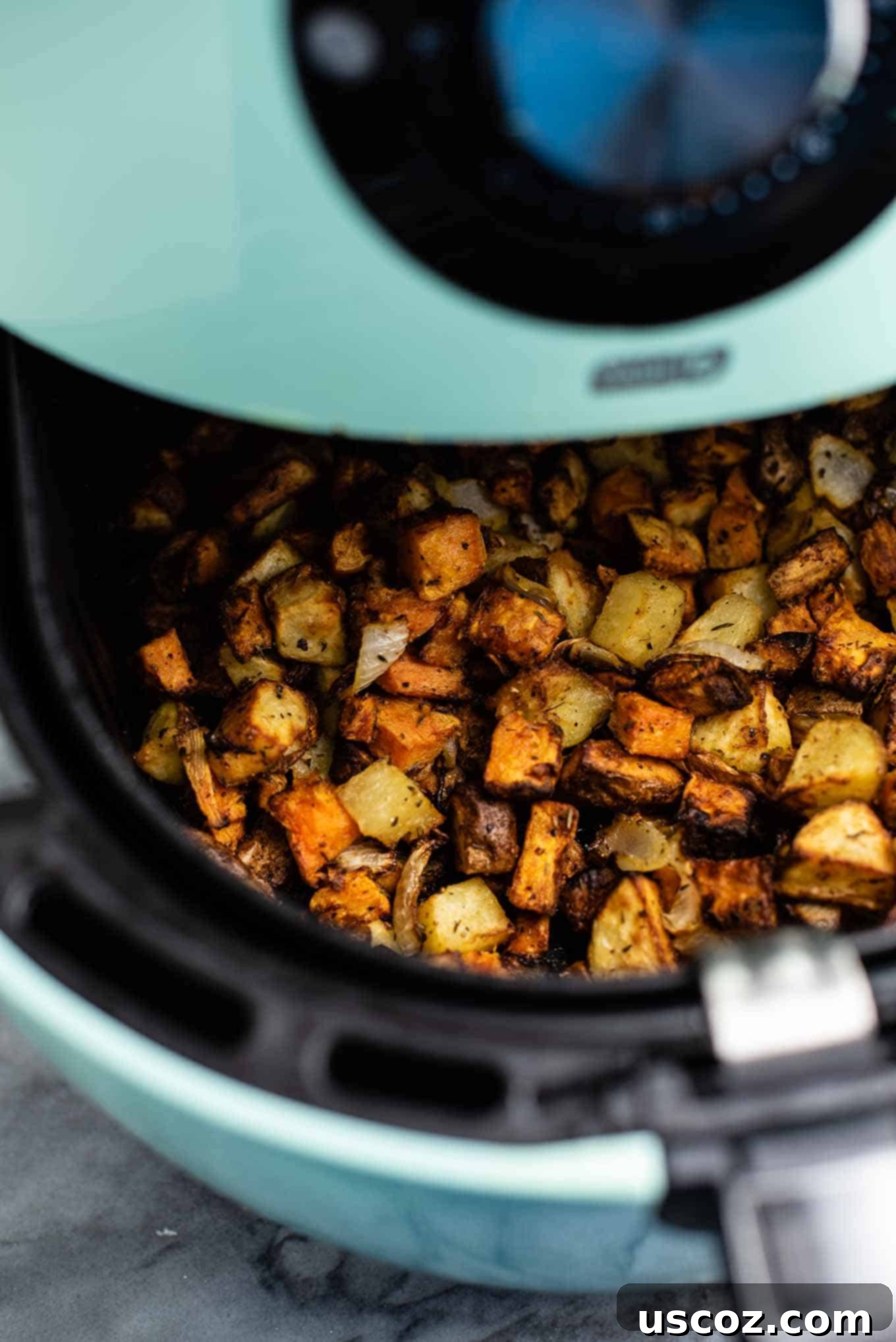 Crispy Air Fryer Breakfast Potatoes 7 Air fryer basket being pulled out, filled with golden brown potato hash