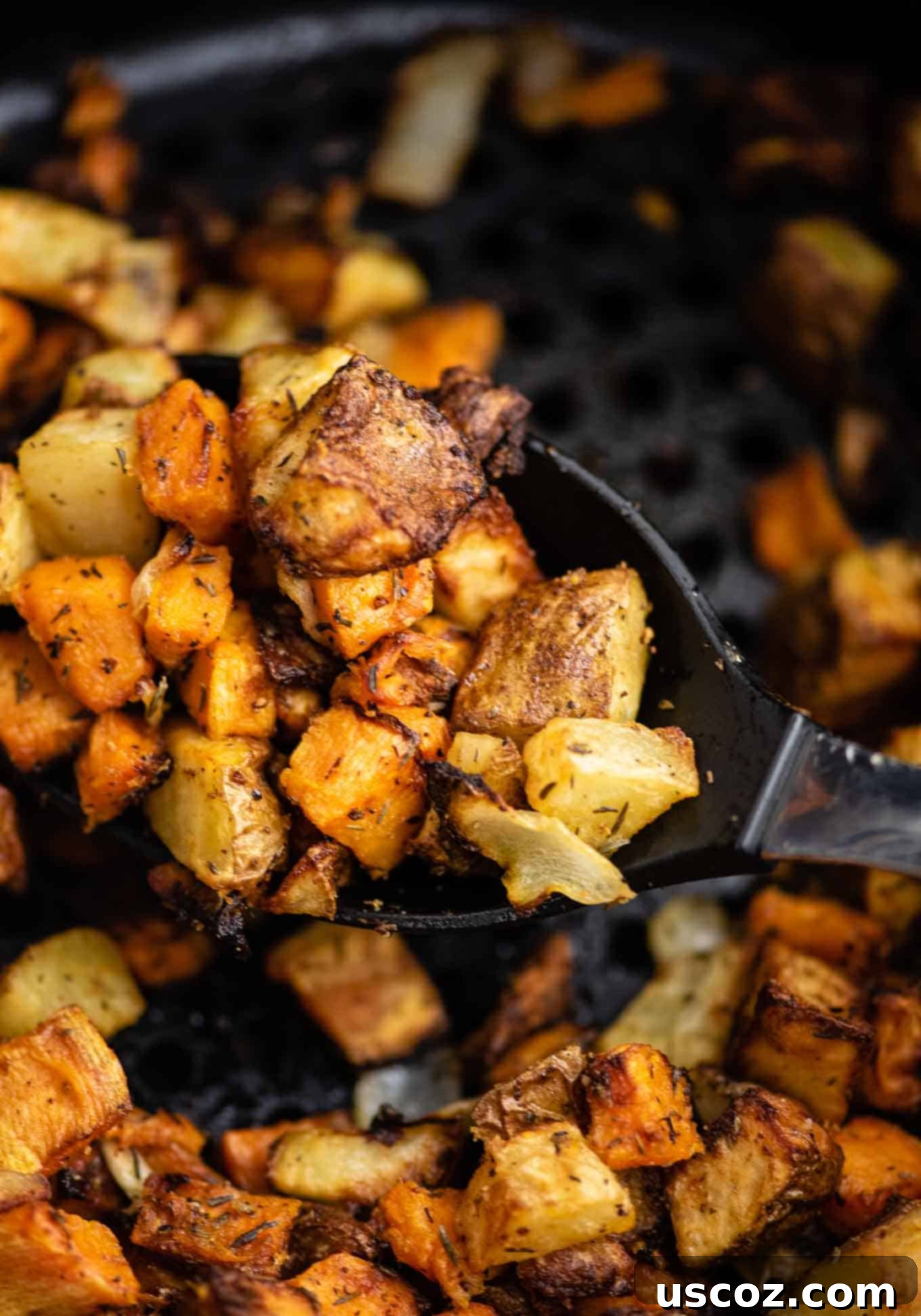Crispy Air Fryer Breakfast Potatoes 9 Serving spoon with crispy air fryer sweet potatoes and russet potatoes