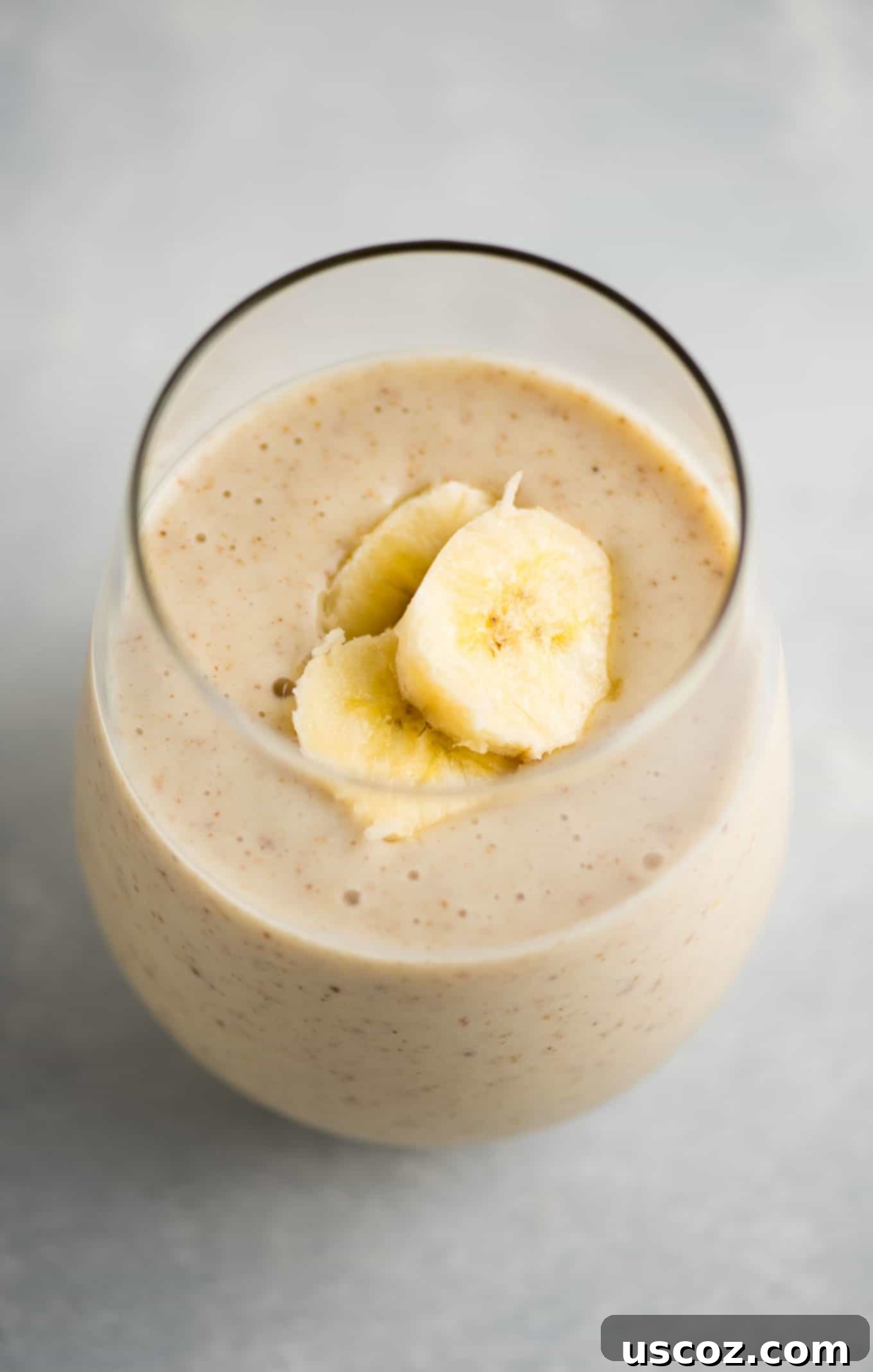 Creamy Banana Delight 5 Overhead shot of a banana smoothie in a glass, emphasizing its cool, inviting appearance.