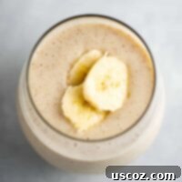 Creamy Banana Delight 7 Creamy banana smoothie in a glass with banana slices on top, featured in the recipe card.