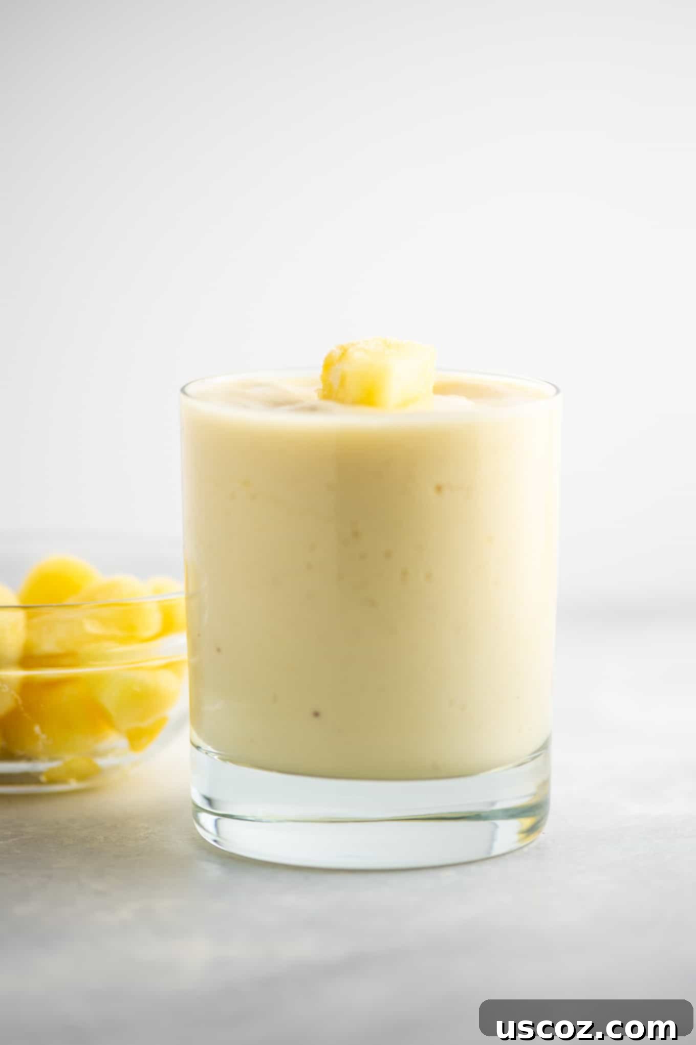 Tropical Pineapple Chill 8 smoothie in a glass with pineapple in the background