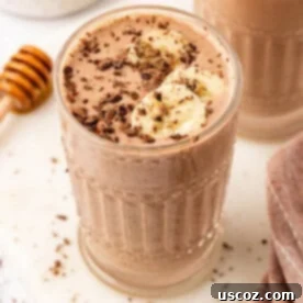 Indulgent Chocolate Peanut Butter Banana Smoothie 11 A delicious and creamy chocolate peanut butter banana smoothie topped with chocolate shavings and banana slices, perfect for a healthy breakfast or snack