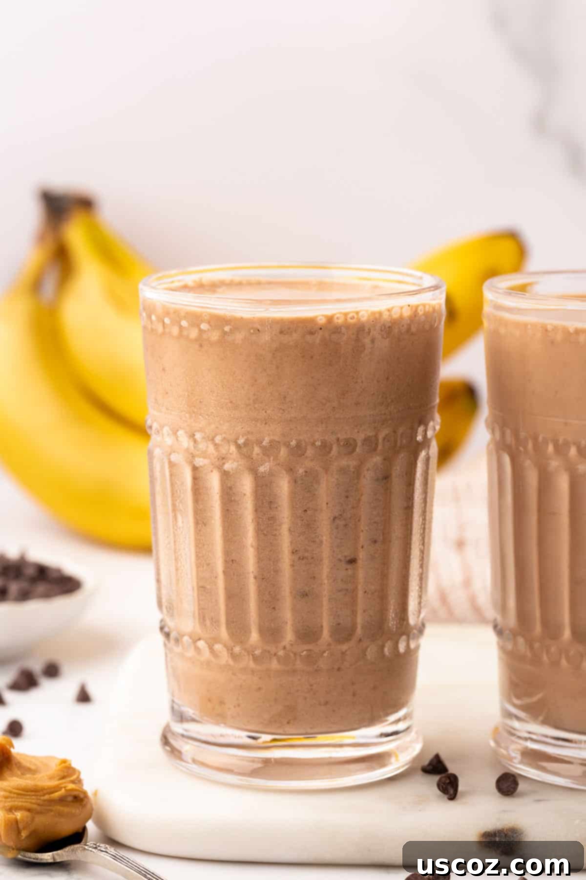Indulgent Chocolate Peanut Butter Banana Smoothie 9 A close-up of a chocolate peanut butter banana smoothie in a glass, showcasing its rich texture and color