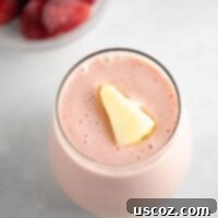 Tropical Strawberry Delight 6 strawberry pineapple smoothie recipe with a piece of frozen pineapple on top