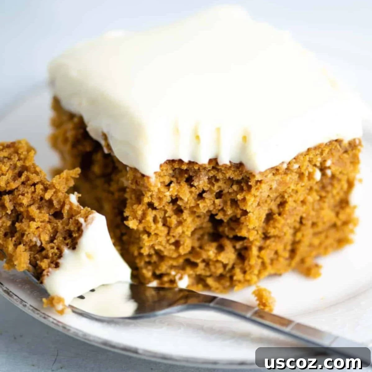 Decadent Pumpkin Cake with Cream Cheese Frosting 2 pumpkin cake recipe with cream cheese frosting slice on a plate with a bite taken out