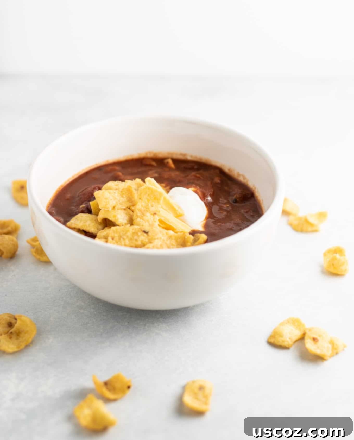 Easy Slow Cooker Vegetarian Chili 6 chili in a bowl with fritos, sour cream, and cheese