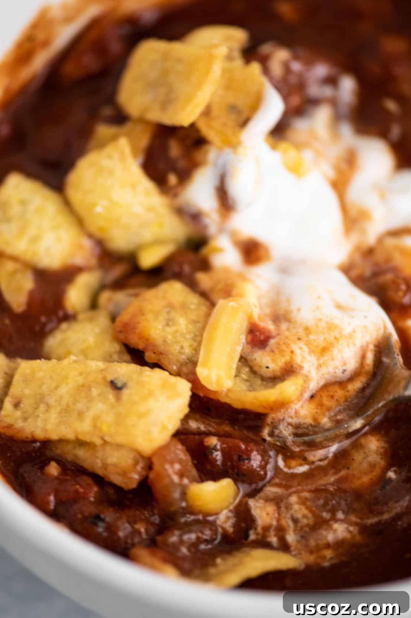 Easy Slow Cooker Vegetarian Chili 9 up close chili topped with sour cream, cheese, and corn chips