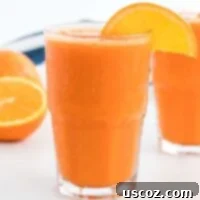 Golden Carrot Orange Smoothie 10 Carrot Orange Smoothie in a glass with an orange slice on the rim