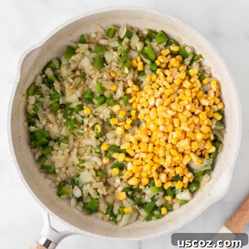 Irresistible Vegetarian Enchiladas 7 adding frozen corn to the vegetables in the skillet