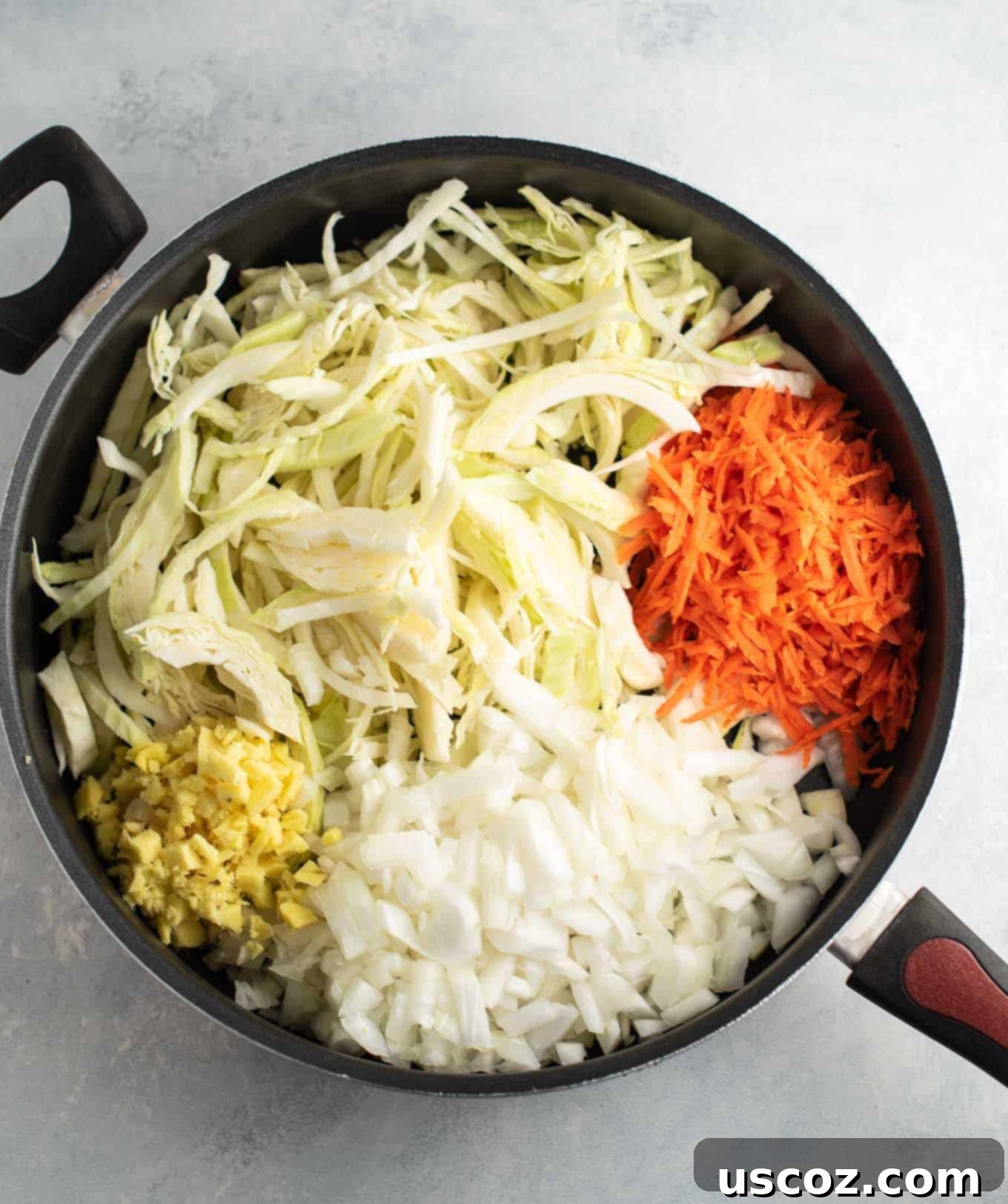 Savory Cabbage Stir Fry 7 raw ginger, onion, cabbage, and carrots in a large skillet, ready to be cooked