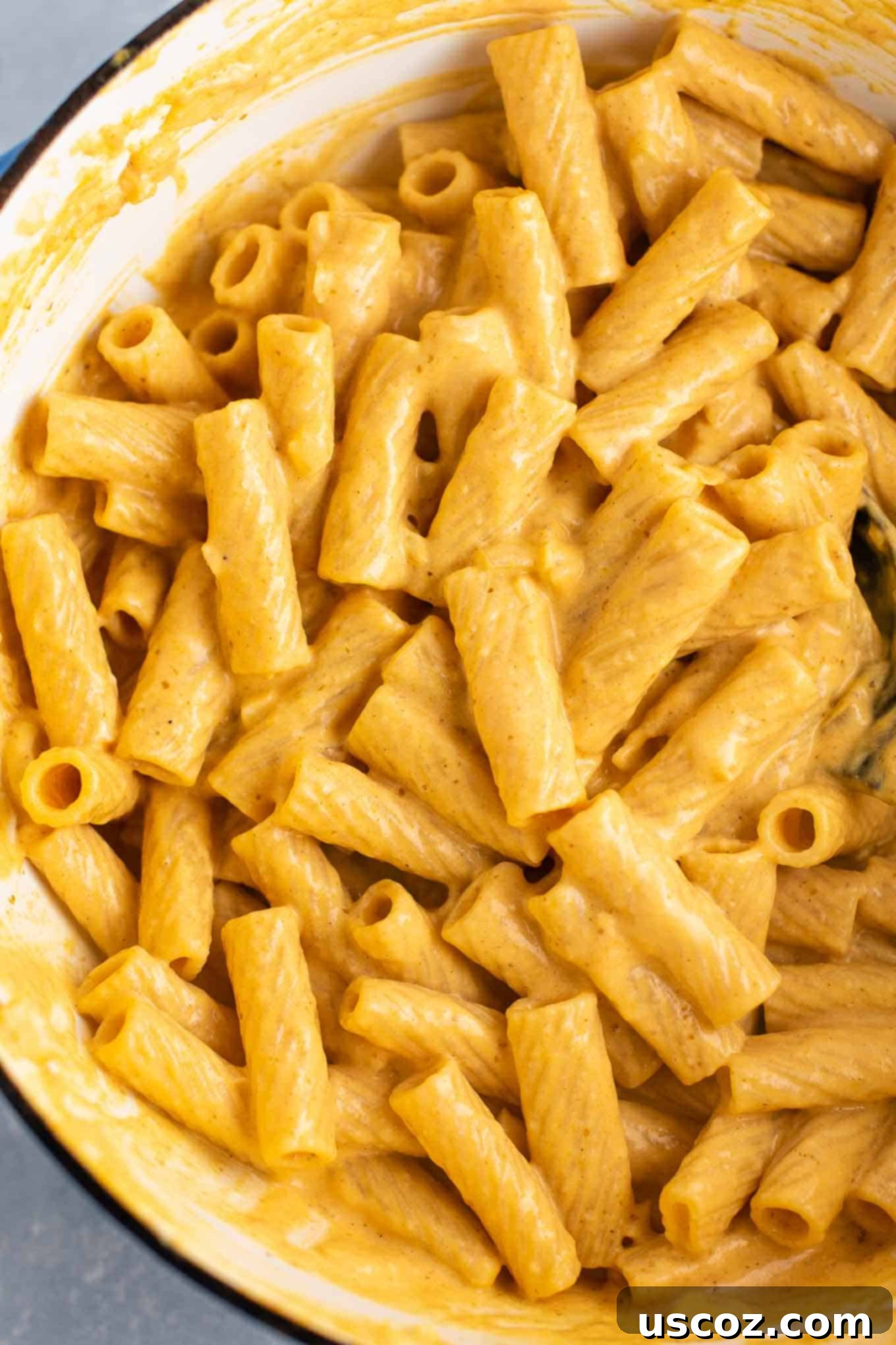 Pumpkin pasta simmering in a Dutch oven, viewed from above, highlighting the creamy texture.
