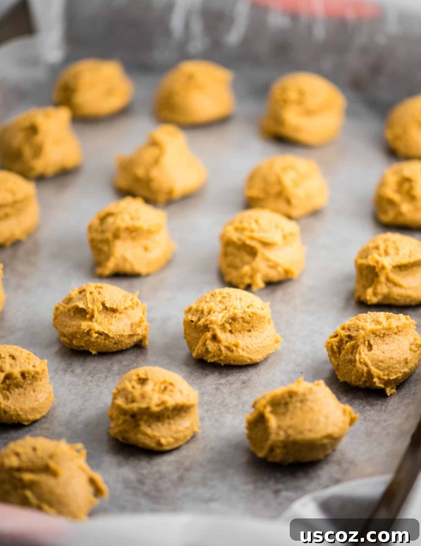 No-Bake Pumpkin Cheesecake Delights 4 pumpkin truffle filling in balls on a baking sheet