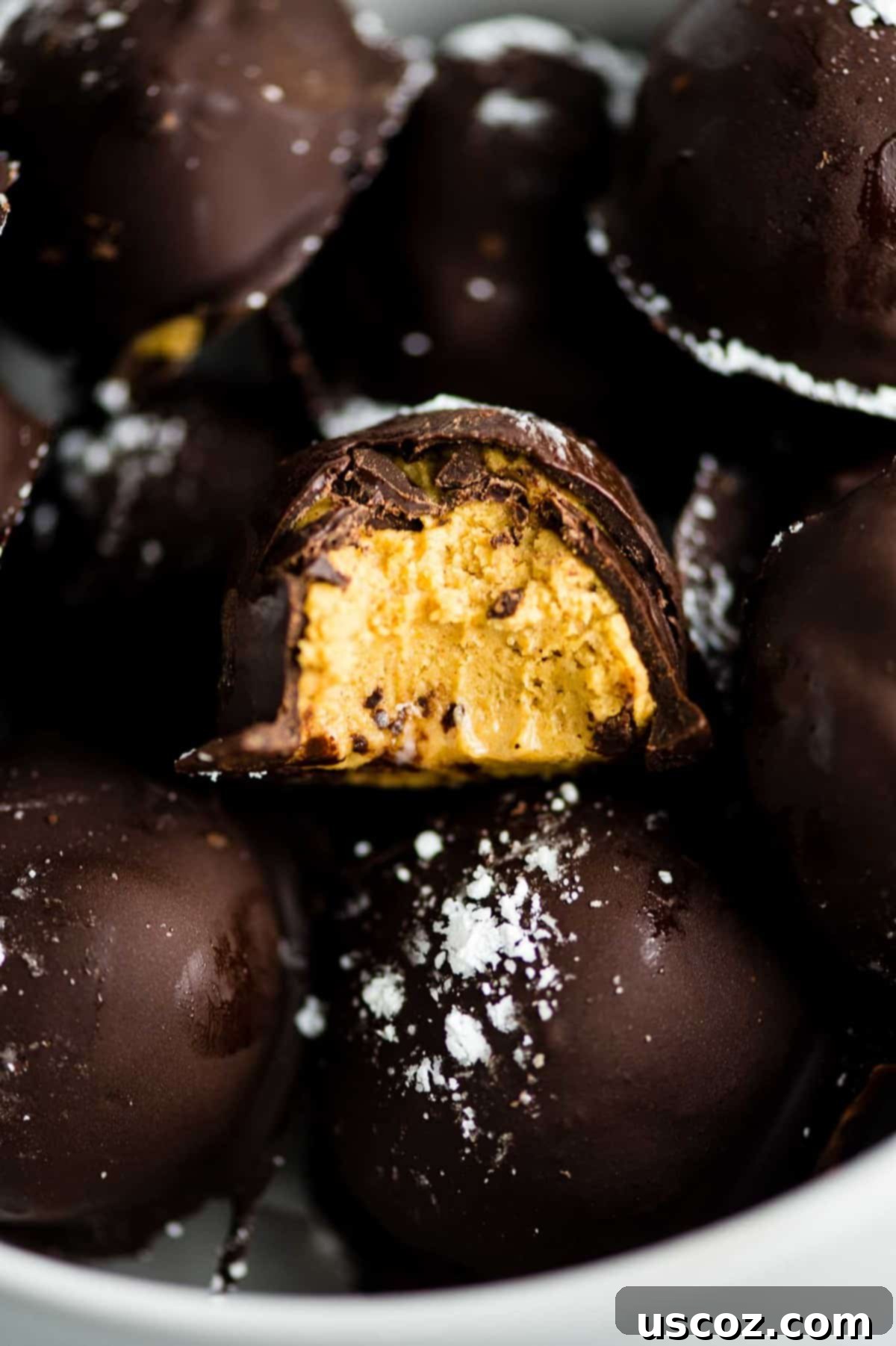 No-Bake Pumpkin Cheesecake Delights 5 dark chocolate pumpkin truffle with a bite taken out