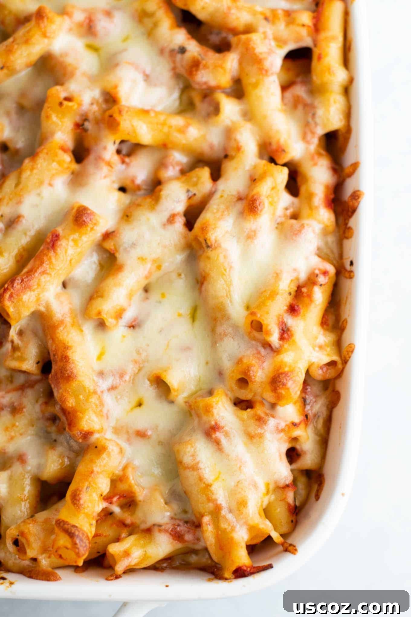 Ultimate Triple Cheese Baked Ziti 2 baked ziti with melted cheese on top, golden brown and bubbling from the oven