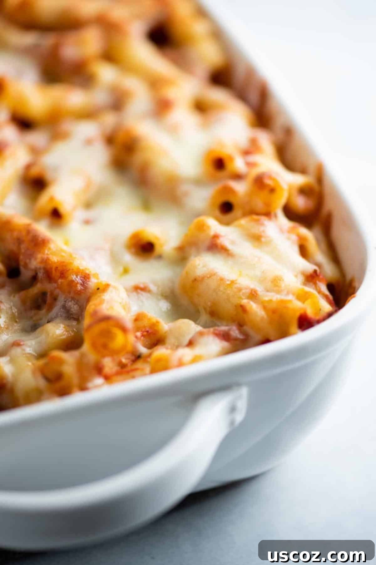 Ultimate Triple Cheese Baked Ziti 3 baked ziti in a white casserole dish, perfectly golden brown and bubbling