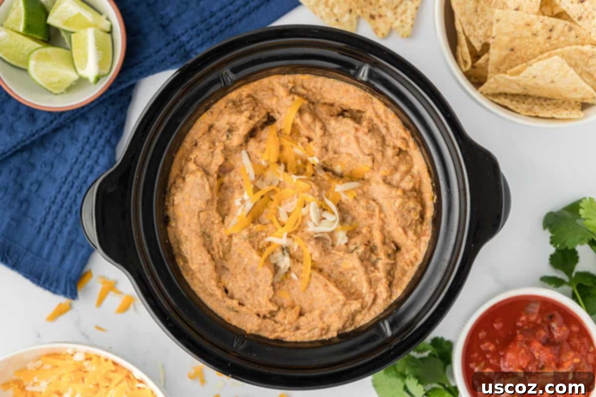 Slow Cooker Fiesta Bean Dip 9 bean dip in a crock pot topped with cheese