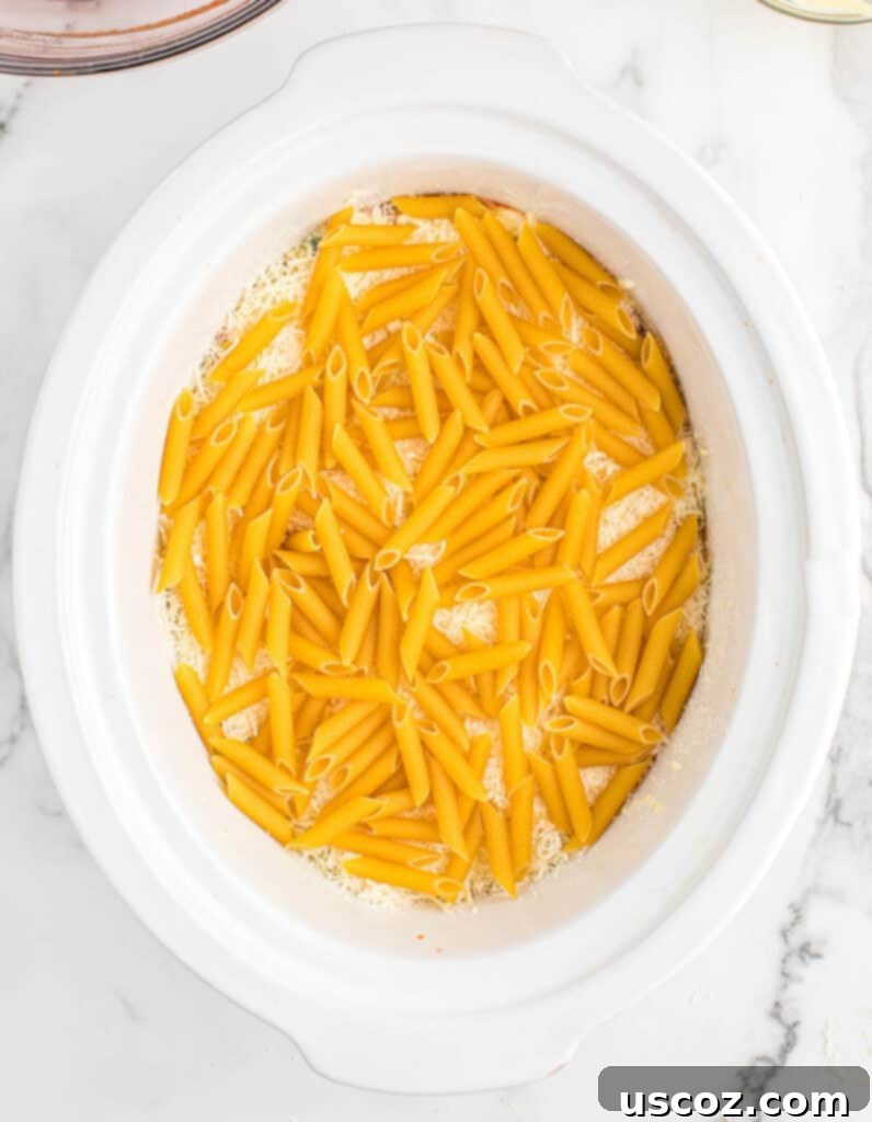 final penne pasta layer added to the crock pot