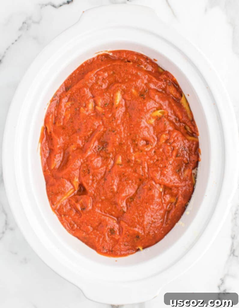 topping the crock pot baked ziti with more sauce
