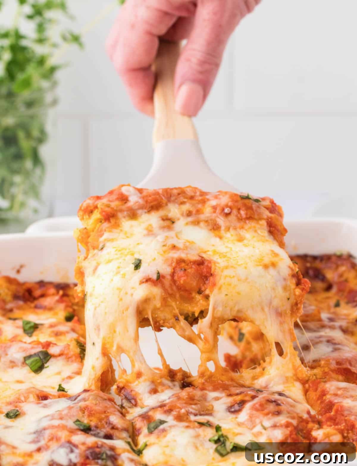 Classic Cheese Lasagna 2 A perfectly golden-brown slice of classic cheese lasagna being lifted from the baking pan, showcasing its luscious layers of pasta, sauce, and three different cheeses.