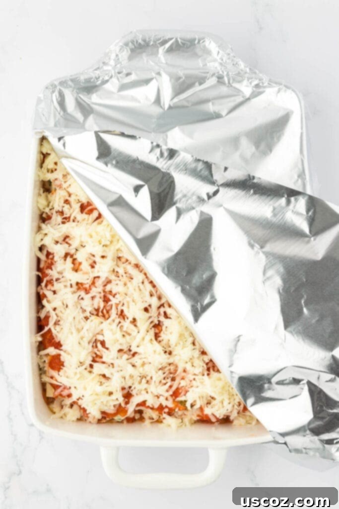 Classic Cheese Lasagna 22 The assembled cheese lasagna in a baking dish, securely covered with aluminum foil, ready to be placed in the oven for baking.