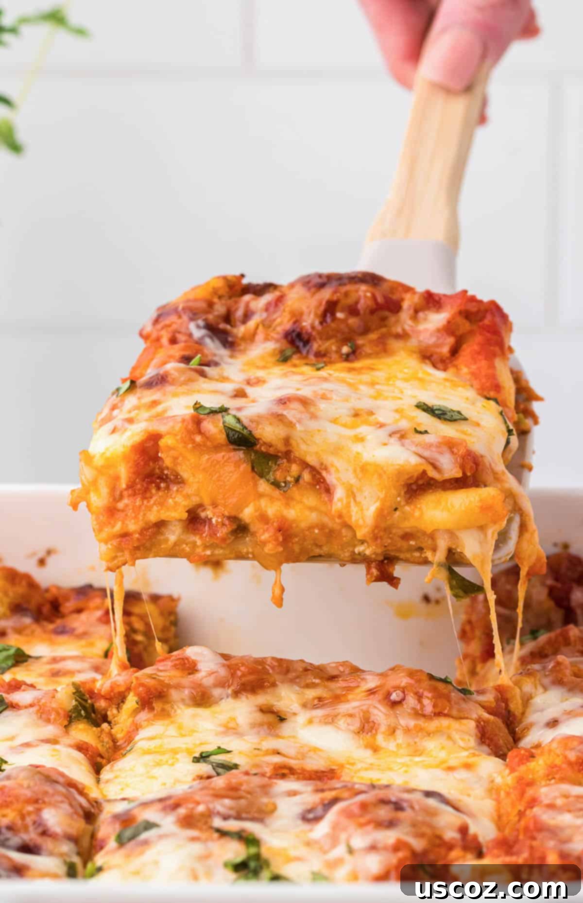 Classic Cheese Lasagna 29 A server lifting a perfectly cut, steaming piece of cheese lasagna from the baking pan with a spatula, revealing the delicious layers beneath.