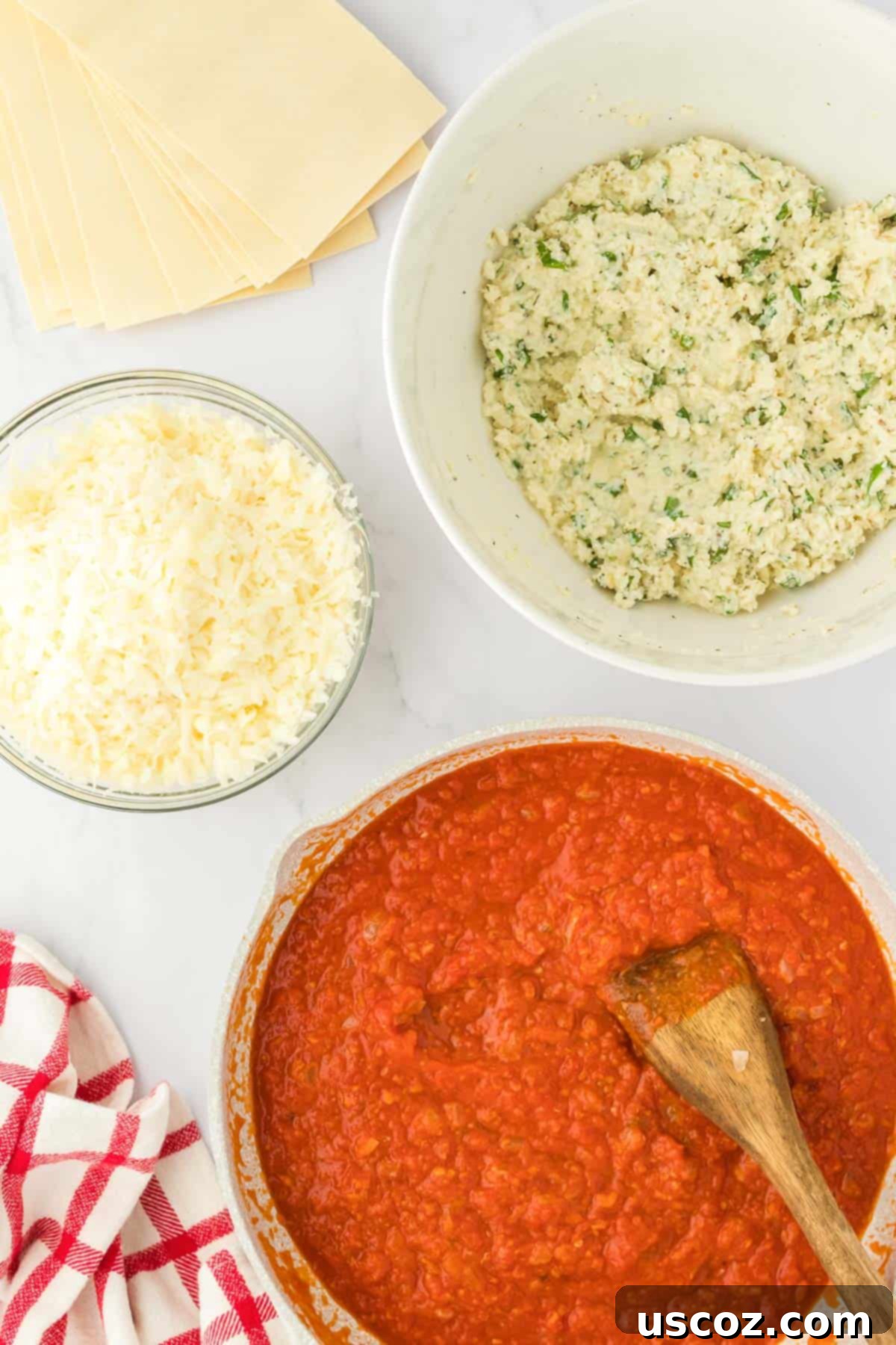 Classic Cheese Lasagna 4 A close-up view of the prepared ingredients on a countertop, ready to be assembled into the lasagna, featuring bowls of ricotta mixture, shredded mozzarella, and pasta sauce.