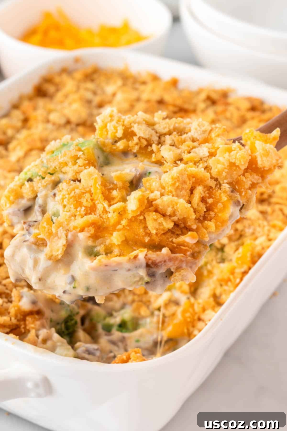 Crispy Ritz Broccoli Bake 15 wooden scoop taking a scoop of ritz broccoli casserole