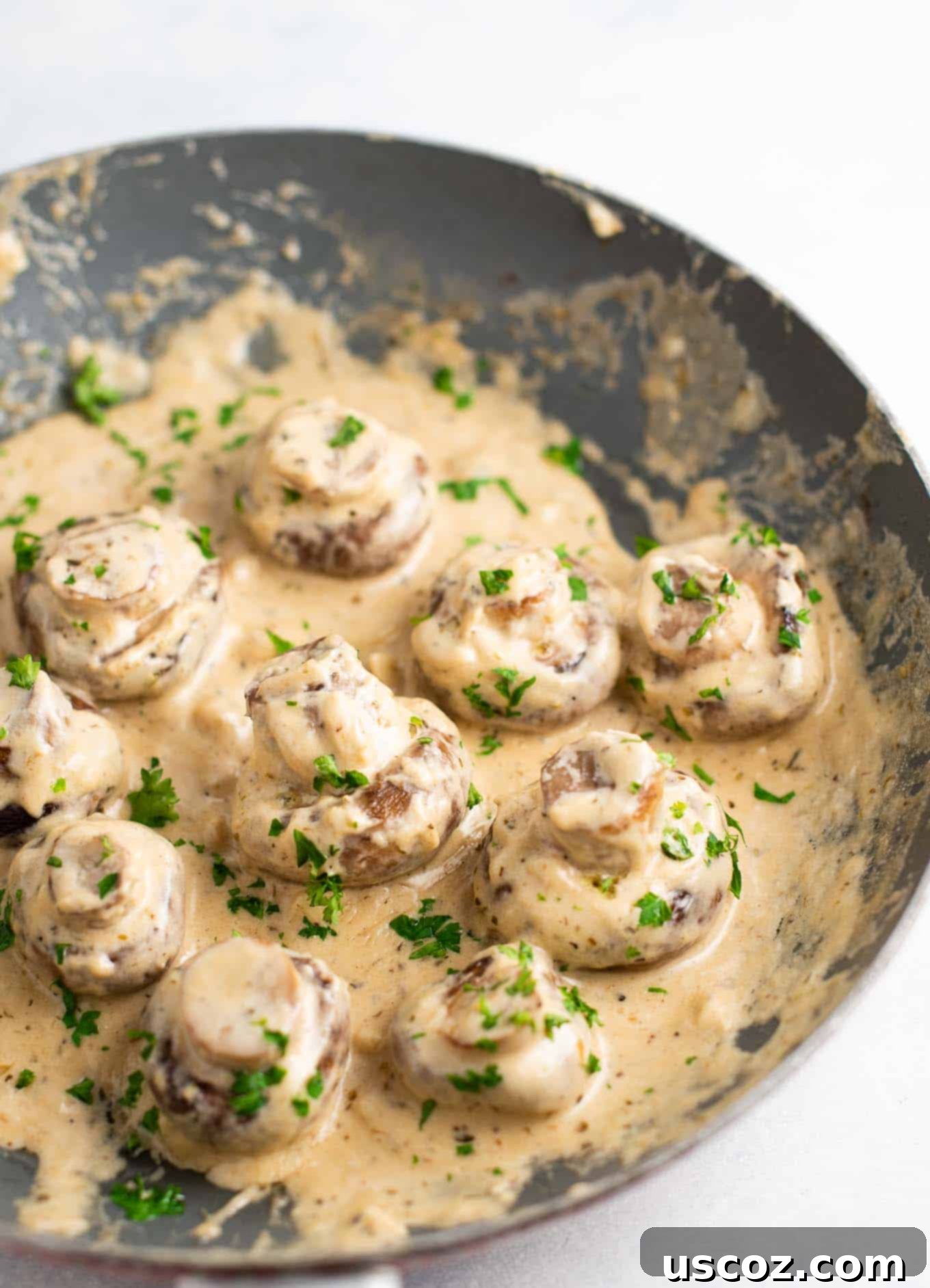 Creamy Garlic Mushroom Delight 2 Sizzling portobello mushrooms smothered in a rich cream sauce, garnished with fresh parsley in a cast iron skillet.