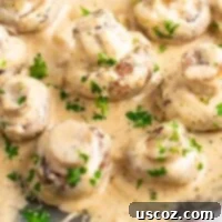 Creamy Garlic Mushroom Delight 7 Sizzling portobello mushrooms smothered in a rich cream sauce, garnished with fresh parsley in a cast iron skillet.