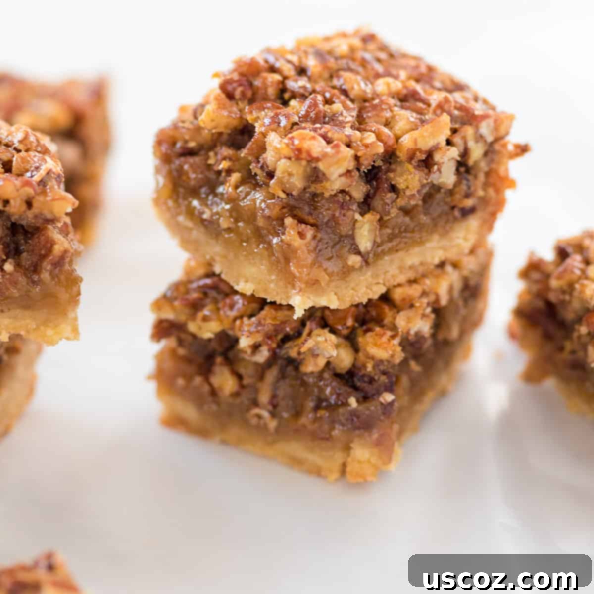 Decadent Pecan Pie Bars 15 pecan pie bars stacked on top of each other